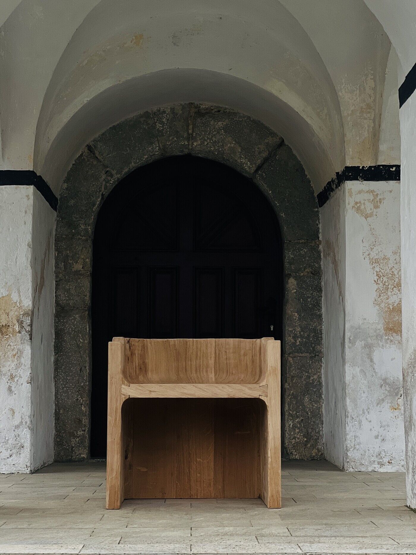 Oak stool set in a weathered stone archway